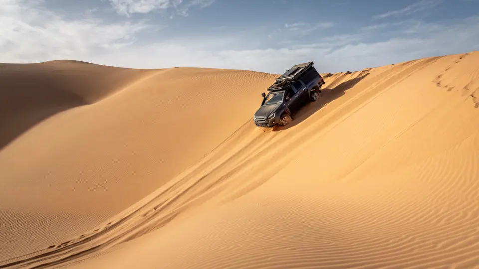 A 4×4 driving through the Erg Chebbi dunes on a Sahara 4×4 tour from Merzouga A 4x4 driving through the Erg Chebbi dunes on a Sahara 4x4 tour from Merzouga
